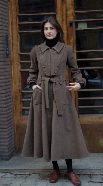 Wełniany płaszcz damski inspirowany stylem retro, z klasycznymi klapami i metalowymi guzikami z przodu.