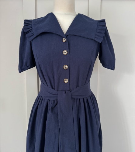 Bawełniana sukienka w kolorze granatowym, z falbankami i dekoltem w V