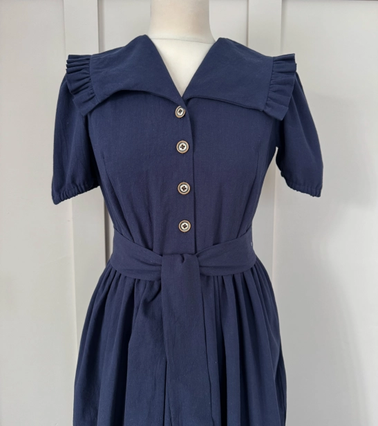 Bawełniana sukienka w kolorze granatowym, z falbankami i dekoltem w V